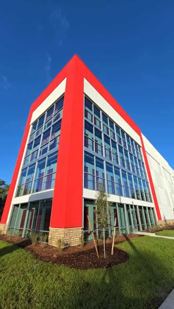Office building with red painted exterior panels and a tall glass front
