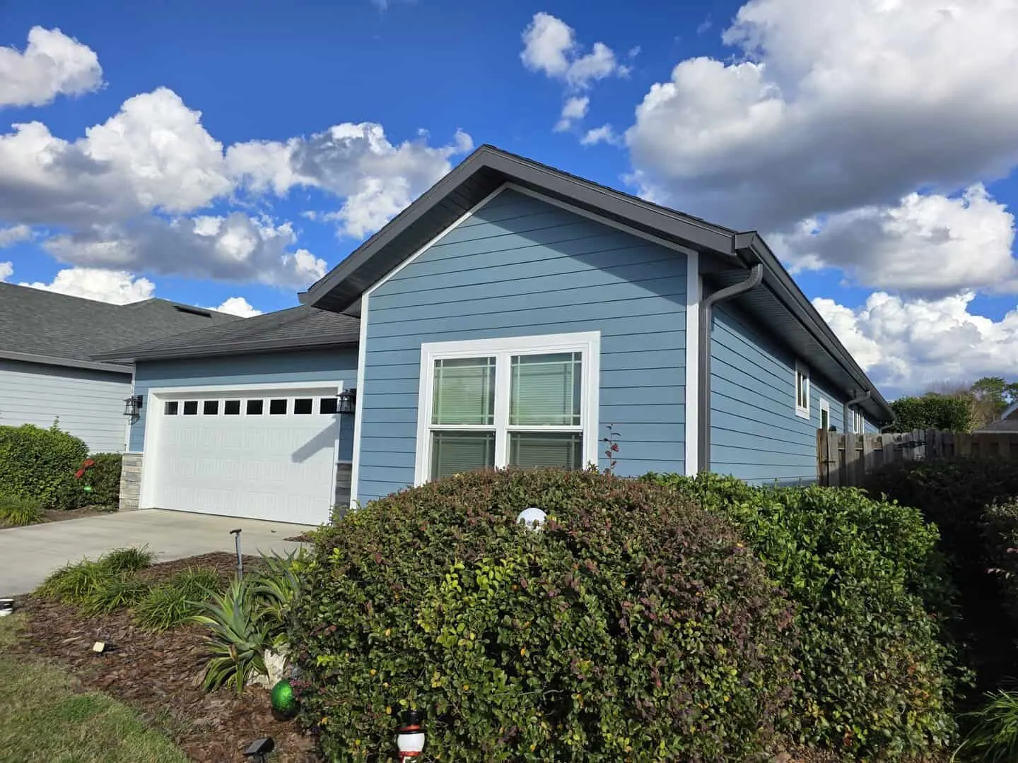 Single-story home in two shades of blue-gray with white trim and a white garage door