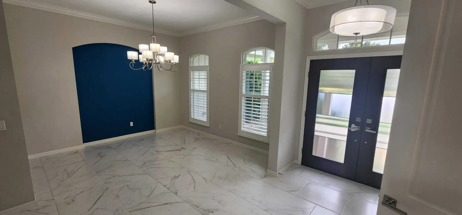 Dining room with light gray walls, white trim and a navy accent wall